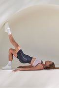 Earthletica Founder Libby Babet wearing the Beyond Set, lying on a white surface in a hip raise position